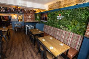 a restaurant with wooden tables and a green wall at The City in Durham