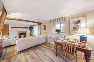 a living room with a table and a couch at Puddle Cottage in Dorchester