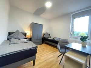a bedroom with a bed and a desk and a table at GWP Apartments in Lohmar +19 photos