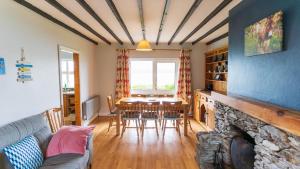 a living room with a table and a fireplace at Crab Cottage - Portmagee in Lateeve