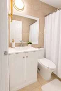 a bathroom with a sink and a toilet and a mirror at Safari Wynwood in Miami