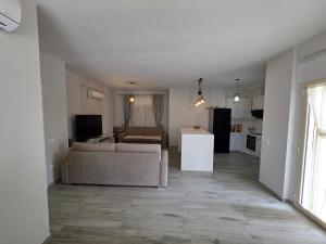 a living room with a couch and a kitchen at PERLA Vision Resort in Draç +11 photos