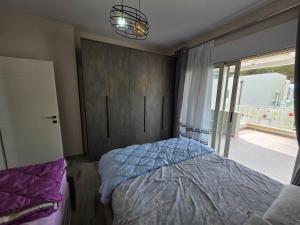 a bedroom with a bed and a large window at PERLA Vision Resort in Draç