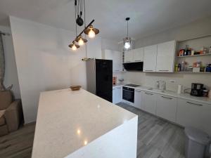 a kitchen with white cabinets and a white counter top at PERLA Vision Resort in Draç