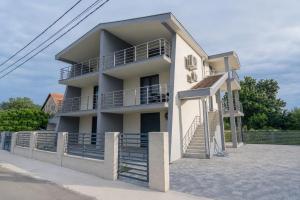 a white building with stairs and a balcony at Allma Kitesurf in Donji Štoj