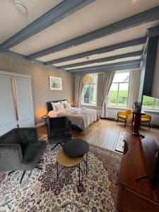 a large bedroom with a bed and a couch at De Stadshoeve in Medemblik