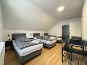 two beds in a room with a table and a desk at GWP Apartments in Lohmar