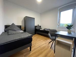 a bedroom with a bed and a desk and a chair at GWP Apartments in Lohmar