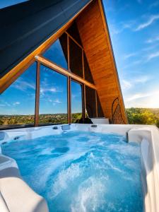 a hot tub in a room with a large window at Vila Mila in Vlaška