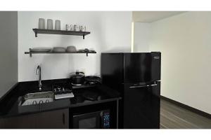 a kitchen with a black refrigerator and a sink at Studio 6 Pocatello, ID in Pocatello