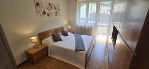 a bedroom with a bed with blue pillows on it at Eve's Home with Garden in Magreglio
