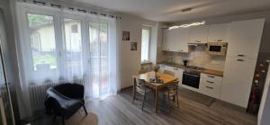 a kitchen with a small table and a table and chairs at Eve's Home with Garden in Magreglio