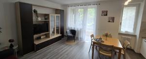 a living room with a dining table and a television at Eve's Home with Garden in Magreglio