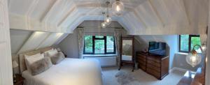 a bedroom with a white bed and a television at The Stanwick Hotel in Stanwick