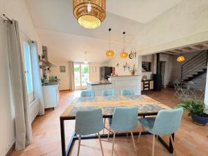 a dining room and kitchen with a table and chairs at L Écrin de Jade Maison de Bourg La MENITRE in La Menitré +3 photos
