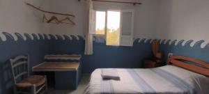 a bedroom with a bed and a desk and a window at Casa Diafa in Órgiva