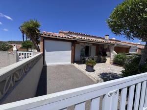 a white fence in front of a house with a garage at HOLIDAYLAND BAIE DES OLIVIERS VILLA 36m2 1chambre fermée 6 couchages ou VILLA 41M2 2chambres fermées 7 couchages in Narbonne-Plage