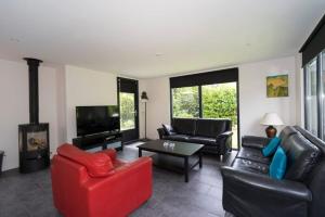 a living room with couches and a fire place at Bremerberg bungalow 50 in Biddinghuizen