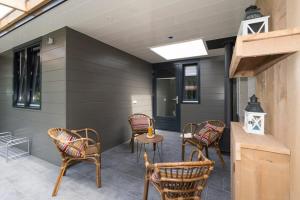 a patio with chairs and a table in a building at Bremerberg bungalow 50 in Biddinghuizen