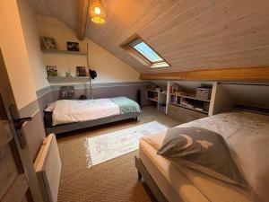 a attic bedroom with two beds and a skylight at L Écrin de Jade Maison de Bourg La MENITRE in La Menitré
