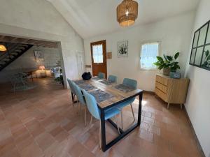 a dining room with a wooden table and chairs at L Écrin de Jade Maison de Bourg La MENITRE in La Menitré