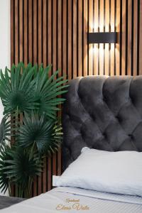 a bedroom with a gray tufted bed and a plant at Elena Vista Apartments in Štip