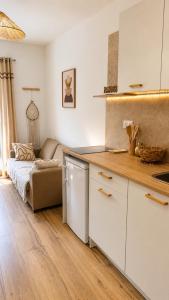 a kitchen with white cabinets and a couch in a room at Casa Luna in Saint-Chamond