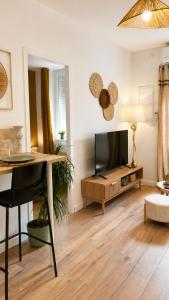 a living room with a desk and a tv at Casa Luna in Saint-Chamond