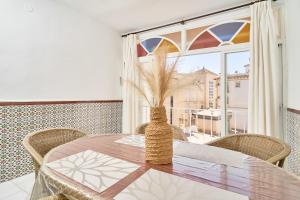 a dining room with a table and a large window at Vivienda junto a Plaza España in Nerja