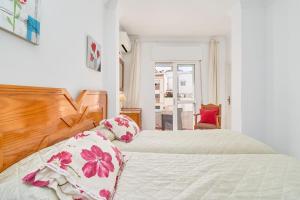 a bedroom with two beds and a window at Vivienda junto a Plaza España in Nerja