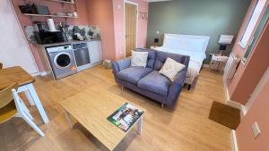 a living room with a couch and a bed and a table at Studio Flat in Seymour Road in Bristol