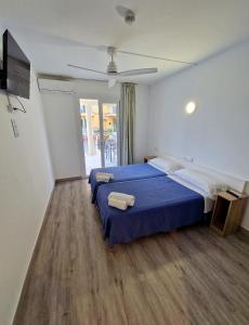 a hotel room with two beds and a tv at Hostal Sol de Mallorca in El Arenal