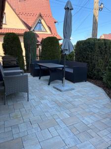 a patio with an umbrella and a table and chairs at Apartament 5 os u Króla in Biały Dunajec