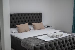 a bedroom with a large bed with a black headboard at Allma Kitesurf in Donji Štoj