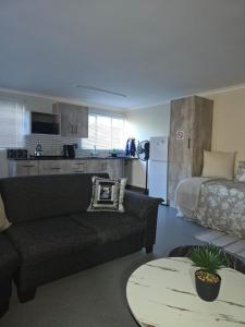 a living room with a couch and a bed at CasaMari guesthouse in Pretoria