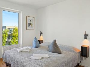 a bedroom with a bed with blue pillows and a window at Apartment Penthouse Seevibes by Interhome in Lembruch