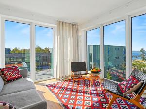 a living room with a couch and chairs and large windows at Apartment Penthouse Seevibes by Interhome in Lembruch