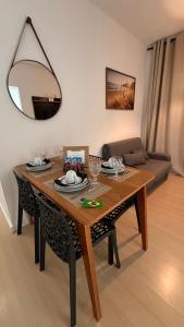 a dining room table with a mirror and a couch at Aracaju Apartamento 2 Quartos Proximo A Orla de Atalaia Praia de Aruana Aeroporto Shopping Sul in Aracaju