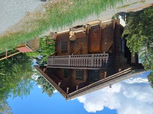 a reflection of a wooden house in the water at Chalet Chalet Le Trèfle by Interhome in Salins