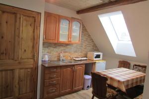 a kitchen with a sink and a table and a window at Privát u koní in Úherce