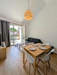 a living room with a wooden table and chairs at Maisonnette proche centre ville et plage in Saint-Brevin-les-Pins