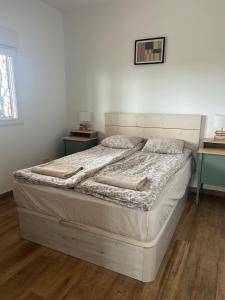 a bed in a white room with two tables and a bed sidx sidx at Villa Remedios -rooms in private house- in Picassent