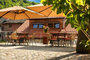 a table and chairs with an umbrella in front of a house at Roserhof Gengenbach in Gengenbach