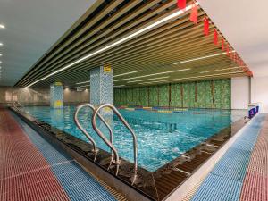 a large swimming pool in a building at Mercure Shenzhen Nanshan in Shenzhen