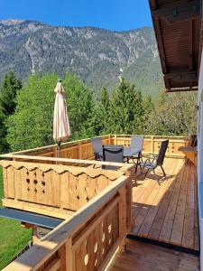 a wooden deck with chairs and an umbrella at Naturidyll Brunner in Köstendorf