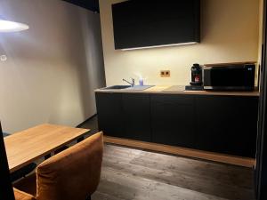 a kitchen with a sink and a microwave and a table at Olivine 12 in La-Roche-en-Ardenne +5 photos