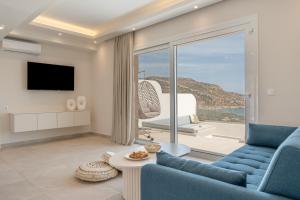 a living room with a blue couch and a view of the ocean at Aqua Blue Villa in Amoopi