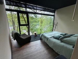 a bedroom with a bed and a large window at Olivine 12 in La-Roche-en-Ardenne