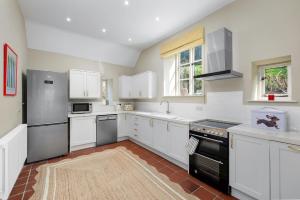 a kitchen with white cabinets and a black refrigerator at Fernhalls Mill in Munslow +6 photos