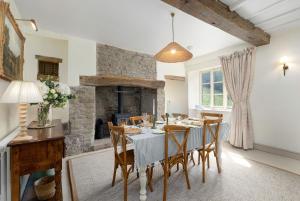 a dining room with a table and a fireplace at Fernhalls Mill in Munslow